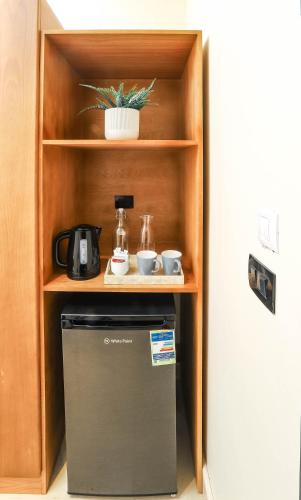 a small refrigerator in a cabinet next to a door at NewCity Hotel & Suites in Cairo