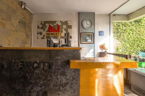 a bar in a restaurant with a clock on the wall at NewCity Hotel & Suites in Cairo