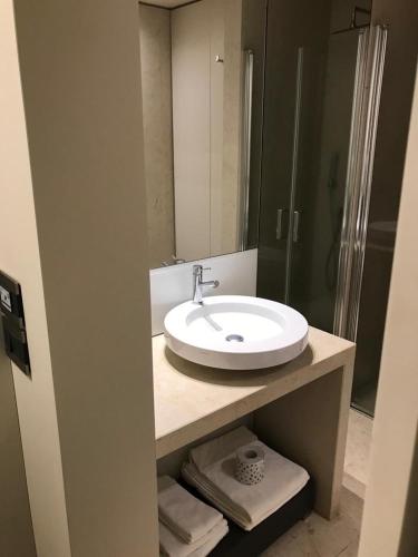 a bathroom with a white sink and a shower at Hotel Romano House in Catania