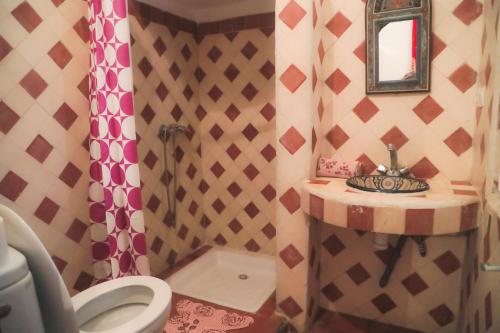 een badkamer met een douche, een toilet en een wastafel bij Riad Dar Afram in Essaouira