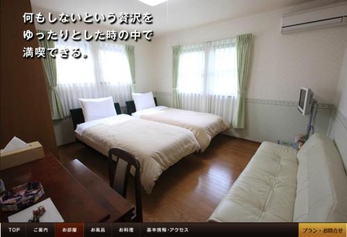 Habitación con 2 camas y sofá. en アルヴィラ近江舞子 en Minami-komatsu