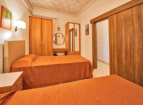a hotel room with two beds and a mirror at BEACHFRONT with Seaviews Apartment No56 Award Winner Unbeatable Location for Closeness to the Sea Ideal for Guests looking for Winter Spring and Autumn Breaks in Sunny Malta Also Ideal for Coastal Hikers in Mellieħa