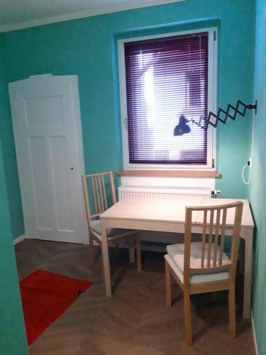 a table and a chair in a room with a window at Die kleine Wohnung in Droyßig