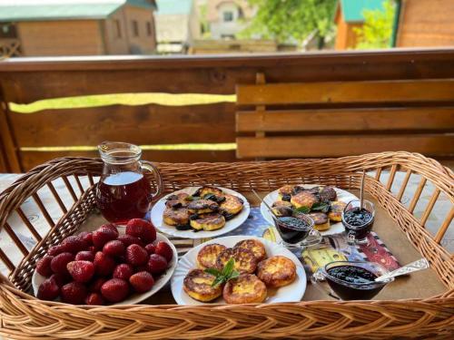 a basket with plates of food on a table at Садиба під Чертежиком 2 in Kolochava