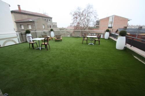 a patio with chairs and tables on a roof at Hotel Cal Piteu in Guisona