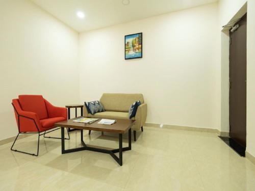 a waiting room with a couch and two chairs at Mayfair Service Apartments in Pīlamedu