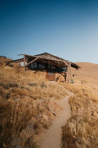 an old building in the middle of a field at Succah in the Desert in Mitzpe Ramon