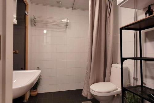 a bathroom with a toilet and a sink and a tub at Modern apartment with free parking & Netflix. in Ylöjärvi