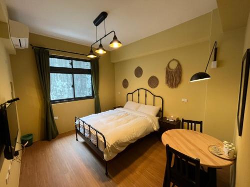 sypialnia z łóżkiem i stołem w obiekcie Lily's House w mieście Zhushan