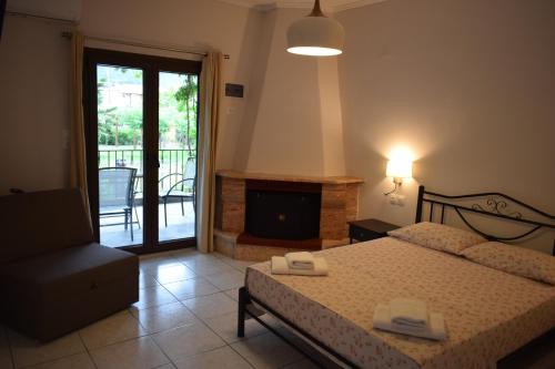 a bedroom with a bed and a chair and a fireplace at House Evristhenis 2 in Toroni