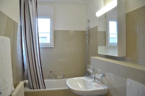a bathroom with a sink and a tub and a shower at Rent a Home Landskronstrasse - Self Check-In in Basel
