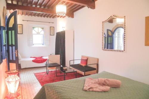 um quarto com uma cama e um espelho na parede em Riad Dar Afram em Essaouira