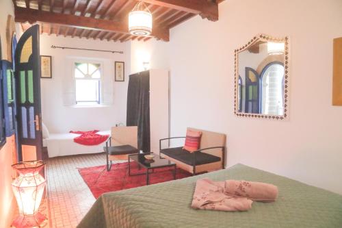 Zimmer mit einem Bett und einem Wandspiegel in der Unterkunft Riad Dar Afram in Essaouira