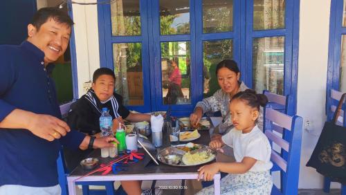 a group of people sitting at a table eating food at Hotel Butterfly - Peaceful Garden for Nature Lovers in Sauraha