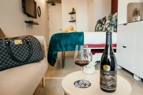 a bottle of wine and a glass on a table at Uxolo Cape Town Living in Cape Town