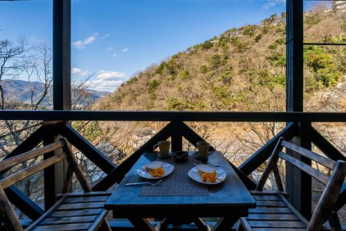 a table on a balcony with a view of a mountain at Suite Villa Minami-Atamigaoka in Atami
