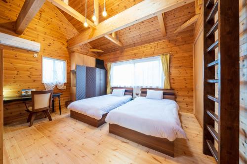 a bedroom with two beds in a wooden cabin at Suite Villa Minami-Atamigaoka in Atami