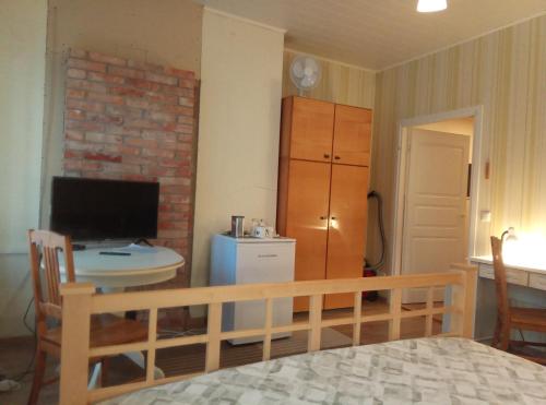 een slaapkamer met een bed, een bureau en een televisie bij Tähe Maja1 in Viljandi
