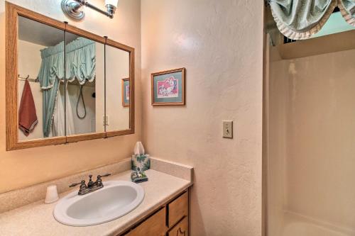 a bathroom with a sink and a mirror and a shower at Peaceful Ranch Cabin, 3 Mi to Becker Lake! in Springerville