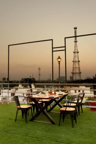 a picnic table and chairs on a field with an antenna at Royale Lalit Hotel Jaipur in Jaipur