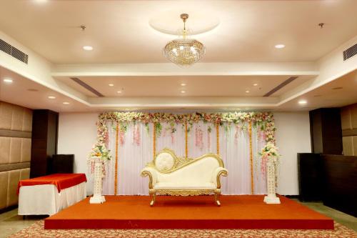 a room with a couch and a stage with flowers at Royale Lalit Hotel Jaipur in Jaipur