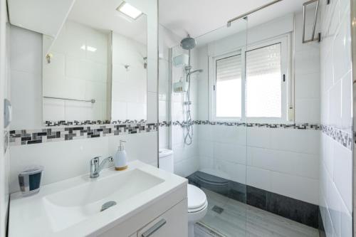 ein weißes Bad mit einem Waschbecken und einem WC in der Unterkunft Solaz-Andaluz City Center Apartment in Torremolinos