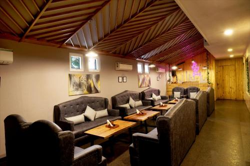 a restaurant with couches and tables and chairs at Royale Lalit Hotel Jaipur in Jaipur