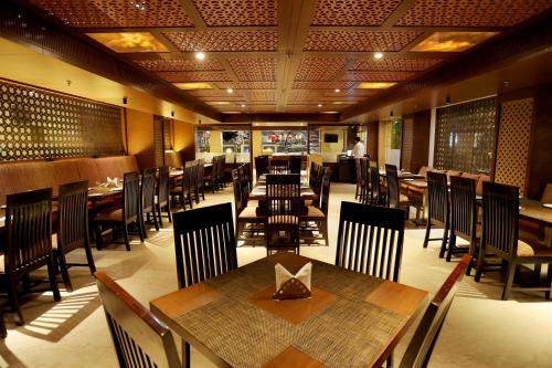 a dining room with tables and chairs in a restaurant at Royale Lalit Hotel Jaipur in Jaipur