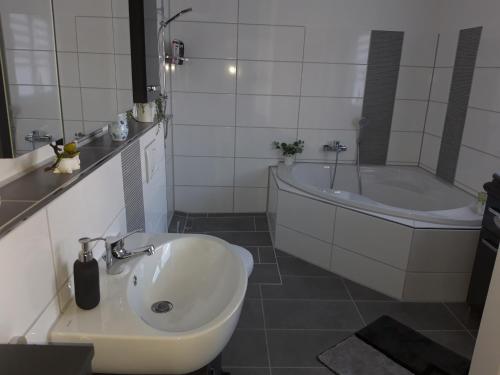 ein Badezimmer mit einer Badewanne, einem Waschbecken und einer Badewanne in der Unterkunft Ferienwohnung Finkenzeller in Jever