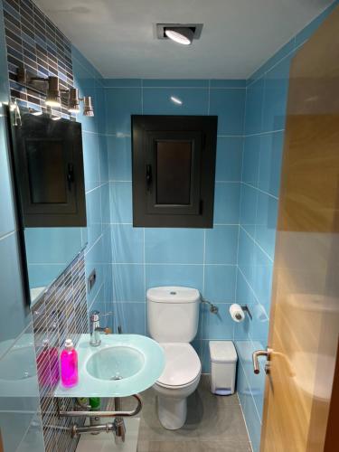 Baño azul con aseo y lavamanos en Apartamento turístico en el centro de Berga, en Berga