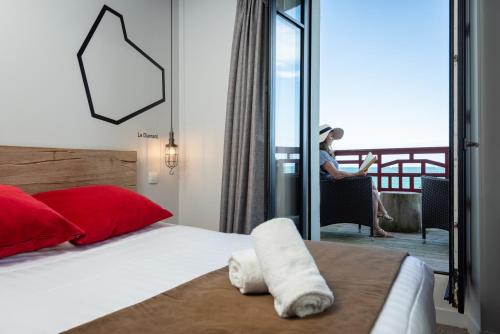 a woman sitting in a chair in a room with a bed at Hôtel Ar Iniz in Saint Malo