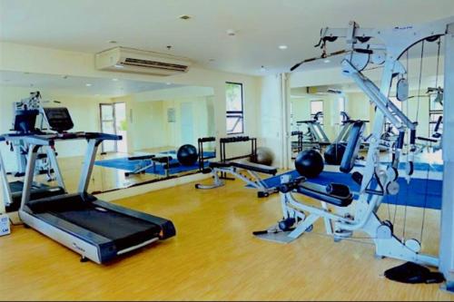 Un gimnasio con varias cintas de correr y máquinas en una sala. en Mabolo Garden Flats 2306, en Cebú