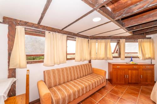 a living room with a couch and two windows at Casa Giuliana in Charco del Pino