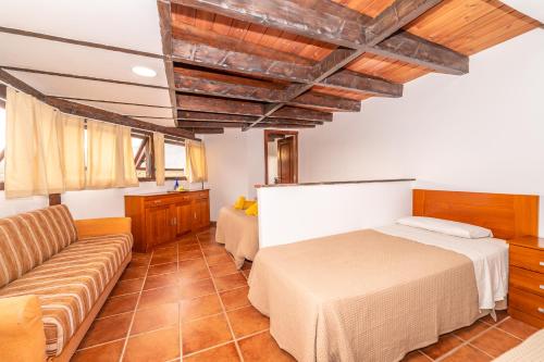 a bedroom with a bed and a couch at Casa Giuliana in Charco del Pino