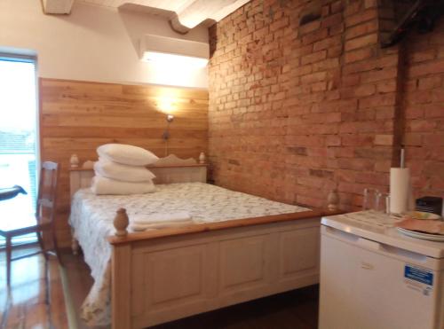 a room with a bed with towels and a brick wall at TäheMaja5 in Viljandi