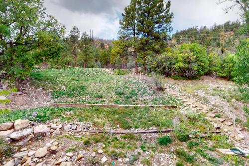 a field with rocks and trees in a forest at Whispering Pines 323 in Durango