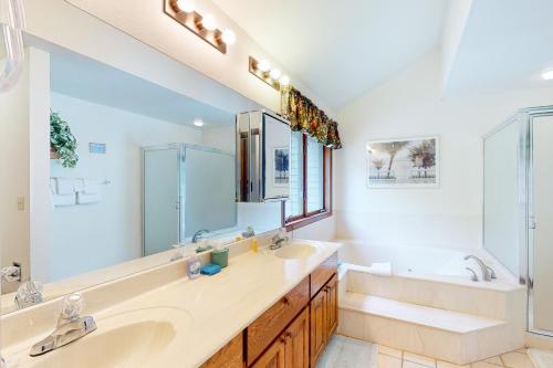 a bathroom with two sinks and a large mirror at Whispering Pines 323 in Durango