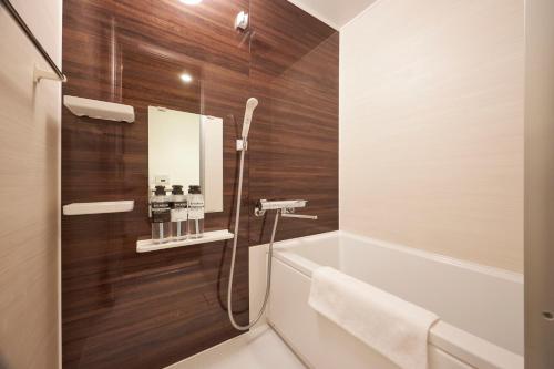 y baño con bañera, lavabo y espejo. en 花築浅草和心ホテル, en Tokio