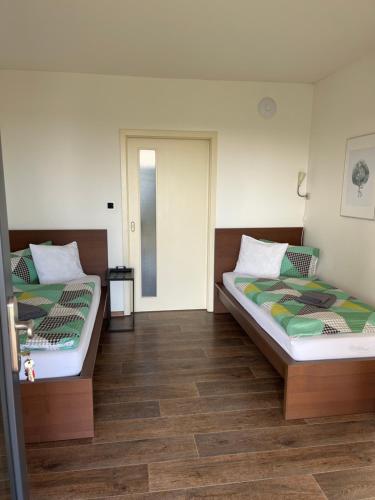 two beds sitting next to each other in a room at Penzion Na Svahu in Cheb