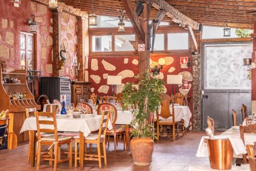 a restaurant with tables and chairs in a room at Casa Giuliana in Charco del Pino