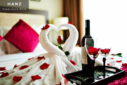 two swans are sitting on a table with a bottle of wine at HANZ Regal Hotel Hanoi in Hanoi