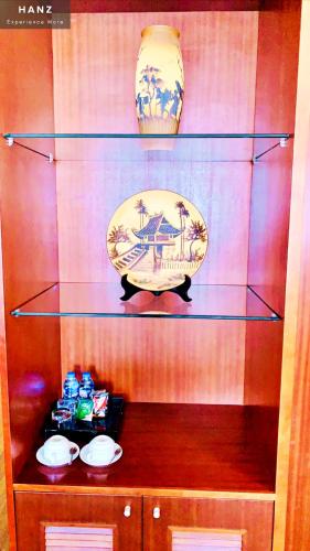 a shelf with two plates and a vase on it at HANZ Regal Hotel Hanoi in Hanoi