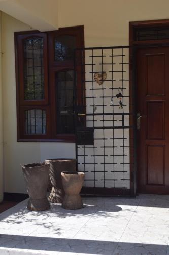 a front door of a house with two vases in front at Stasumo House Arusha in Arusha