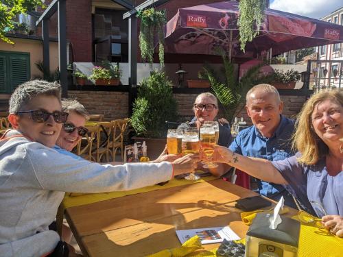 un grupo de personas sentadas en una mesa con copas de cerveza en Serendipity Cottage Palamartsa en Palamarza