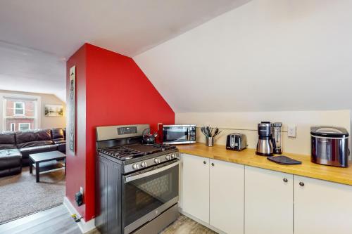 a kitchen with a stove and a red wall at East End Annex in Portland