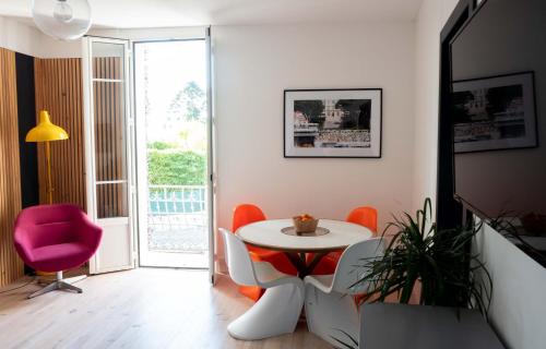 ein Wohnzimmer mit einem Tisch und einem rosa Stuhl in der Unterkunft Modern appartment in the heart of Cap d'Antibes in Antibes