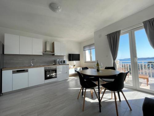 une cuisine et une salle à manger avec une table et des chaises dans l'établissement Apartments Baldo, à Orebić