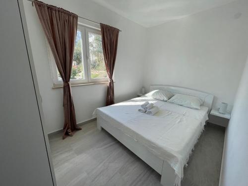 une petite chambre avec un lit et une fenêtre dans l'établissement Apartments Baldo, à Orebić