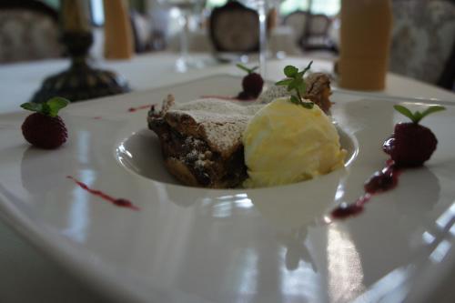 - un dessert avec crème glacée et fraises sur une assiette blanche dans l'établissement Dwór Słupia, à Zarzecze