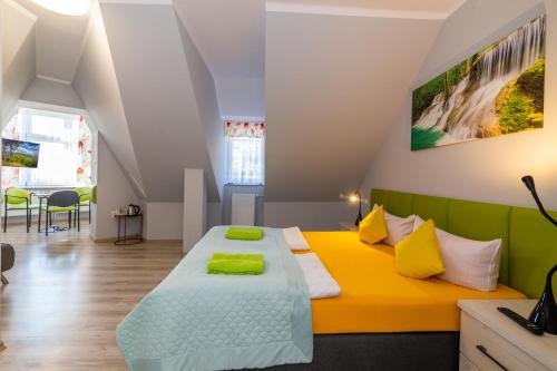 a bedroom with a bed with yellow and green at Willa Diament in Kudowa-Zdrój